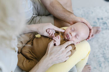 Frau mit Baby auf dem Schoß sitzt bei einem Mann zu Hause - TYF00260