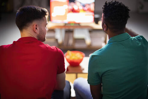 Männer unterhalten sich bei einem Fußballspiel zu Hause miteinander - SBAF00106