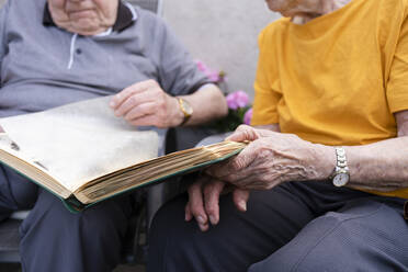Ältere Frau mit Mann beim Betrachten eines Fotoalbums - SVKF00290