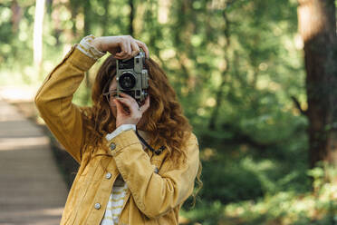 Frau fotografiert durch Kamera im Wald - VPIF06545