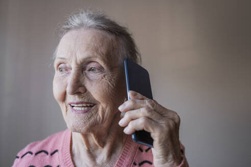 Glückliche ältere Frau, die mit einem Smartphone telefoniert - OSF00061