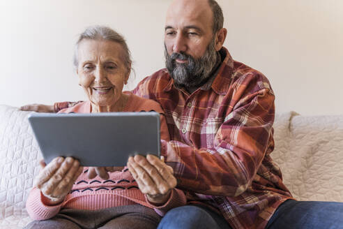 Mann bringt Seniorin zu Hause Tablet-PC bei - OSF00066