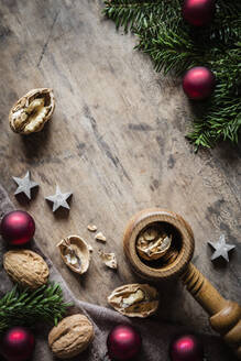 Studio shot of cutting board, twigs, Christmas ornaments, walnuts and simple nutcracker - EVGF04028