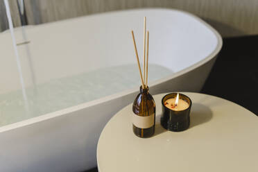 Man relaxing in bathtub with lighted candles arround stock photo