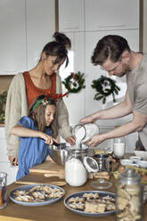 Familie macht Plätzchenteig in der Küche zu Hause - ABIF01758