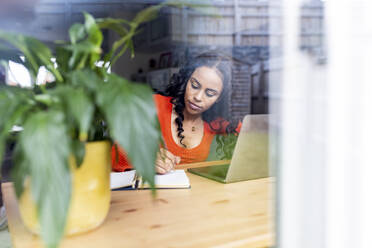 Woman working in front of laptop at home office - WPEF05991