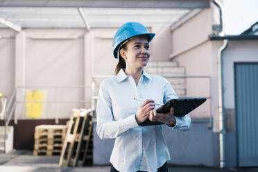 Lächelnde Architektin mit Tablet-PC in einer Fabrik - JOSEF10523