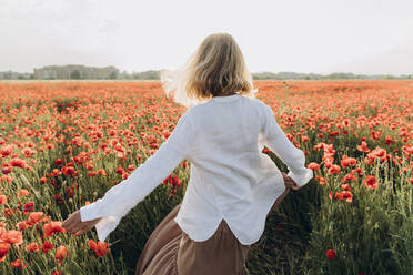 Woman dancing in poppy field - SIF00173