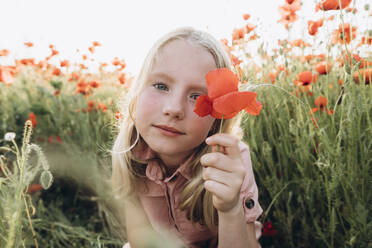 Blondes Mädchen hält rote Blume in Mohnfeld - SIF00185