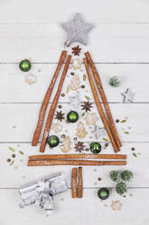 Studioaufnahme einer Weihnachtsbaumform aus verschiedenen Gewürzen, Keksen und Weihnachtsschmuck - GWF07454