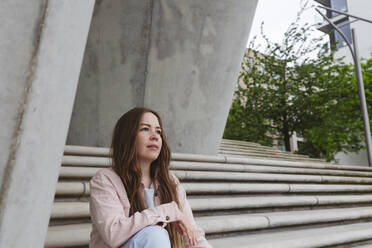 Thoughtful young woman sitting on steps - IHF00943