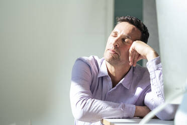 Mature businessman taking nap at desk in office - JOSEF10675