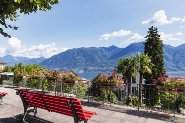 Schweiz, Tessin, Locarno, Parkbank mit Blick auf den Lago Maggiore und die umliegenden Berge im Sommer - GWF07463