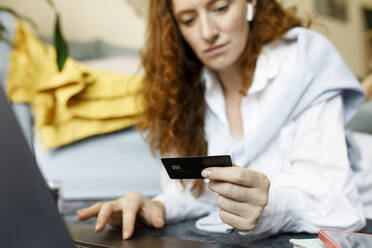 Woman using credit card for online shopping at home - TYF00312