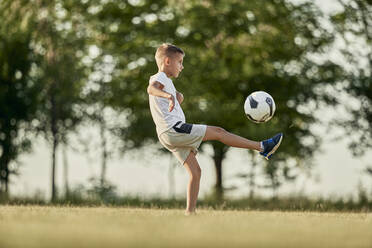 Boy playing soccer on sunny day - ZEDF04675