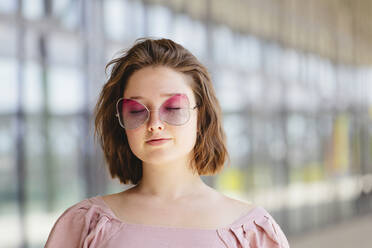 Teenager-Mädchen mit geschlossenen Augen und rosa Sonnenbrille - IHF01014