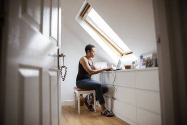 Reife Frau arbeitet von zu Hause aus am Laptop im Schlafzimmer - CAIF32937