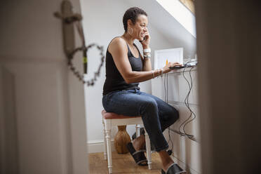 Reife Frau arbeitet von zu Hause aus am Laptop - CAIF32950