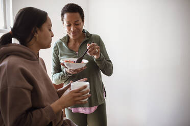 Mutter und Tochter essen Obst und trinken Kaffee - CAIF32970