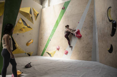 Frau beobachtet Freund an der Kletterwand - CAIF33051