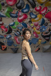 Porträt einer selbstbewussten Bergsteigerin, die unter einer Felswand steht - CAIF33058