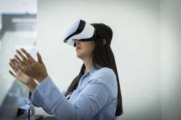 Woman gesturing, using VR headset - CAIF33148