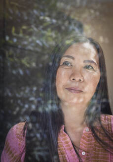 Close up thoughtful woman looking out window - CAIF33180