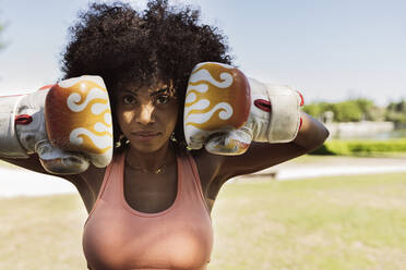 Afro-Frau mit Boxhandschuhen im Park - JCCMF06535