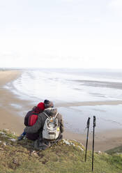 Zärtliche Wanderer Paar umarmt auf Klippe mit Blick auf den Ozean Strand - CAIF33315