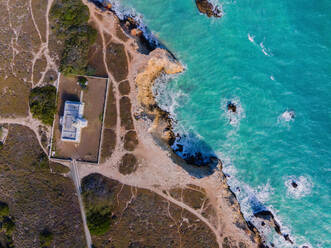 Drone Ansicht des Hauses auf raue Küste mit grünen Pflanzen in der Nähe von plätschernden Meer mit klarem Wasser am Sommertag gelegen - ADSF35028