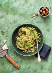 From above ceramic plate with hazelnut pesto spaghetti on green table surface - ADSF35341