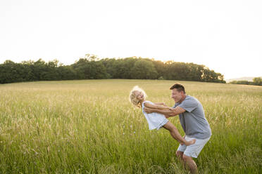 Father and daughter having fun in field - SVKF00336
