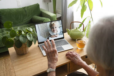 Frau führt Videogespräch mit Enkelin über Laptop zu Hause - SVKF00346
