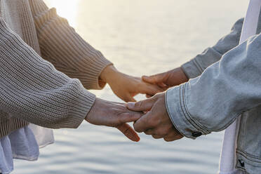 Man holding girlfriend's hands at beach - OMIF00939