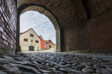 Schweden, Halland, Varberg, Fußweg mit Kopfsteinpflaster und Bogenausgang in der Festung Varberg - STSF03248