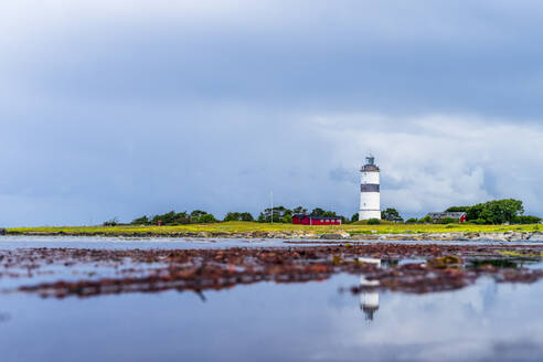 Sweden, Halland, Falkenberg, Cloudy sky over lighthouse in Morups Tange reserve - STSF03253