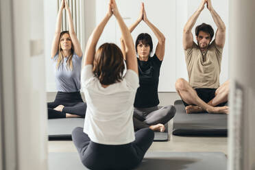 Mann und Frau lernen Yoga von einem Lehrer im Fitnessstudio - JSRF02123