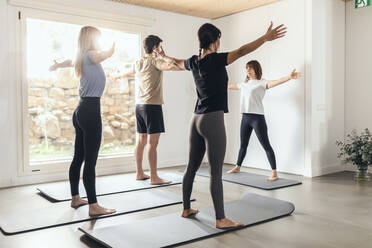 Instructor teaching yoga class in health club - JSRF02124