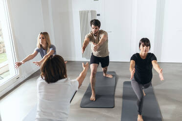 Man and women practicing yoga in exercise class - JSRF02127