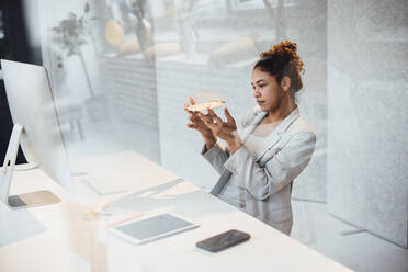 Young businesswoman examining architectural model at office - JOSEF10754