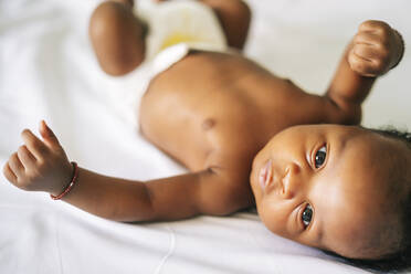 Cute shirtless newborn baby boy lying on bed at home - OCMF02495