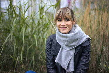 Lächelnde Frau mit Schal vor Gras auf einem Feld - JOSEF10804