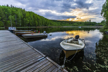 Schweden, Bezirk Vastra Gotaland, Motorboote am Steg des Sees Vastra Silen bei Sonnenuntergang - STSF03268