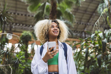 Contemplative woman holding smart phone - JCCMF06587