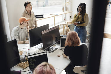 Männliche und weibliche Unternehmer planen eine Strategie während eines Treffens im Büro eines Tech-Start-ups - MASF30867