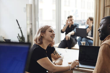 Männliche und weibliche Computerprogrammierer diskutieren im Büro eines Start-up-Unternehmens - MASF30924