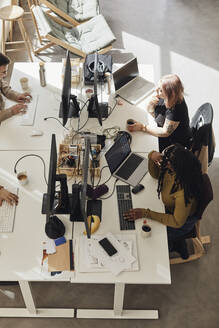 Blick von oben auf Computerprogrammierer bei der Arbeit am Schreibtisch im Büro eines Start-up-Unternehmens - MASF30934