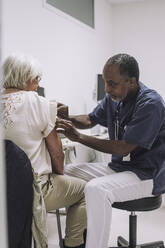 Älterer männlicher Arzt untersucht ältere Patientin in medizinischer Klinik - MASF31217