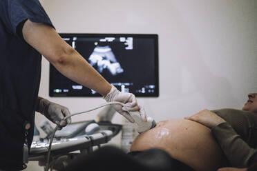 Female gynecologist doing ultrasound of pregnant woman in hospital - MASF31227