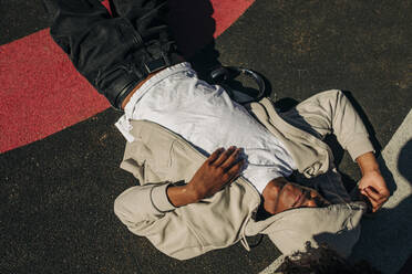 Directly above shot of young man lying at playground on sunny day - MASF31342